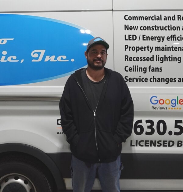A man standing in front of a van with the words electric, inc on it.